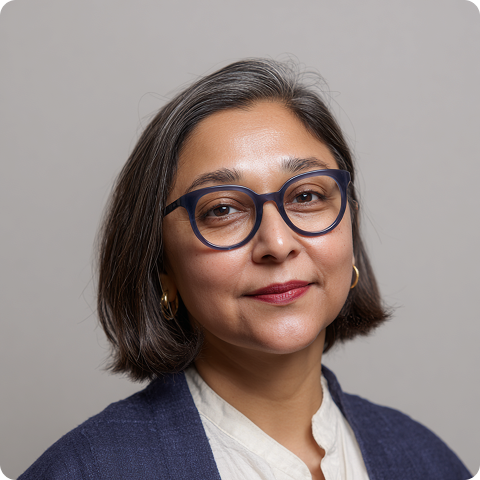 Woman with short dark hair and glasses smiling at the camera