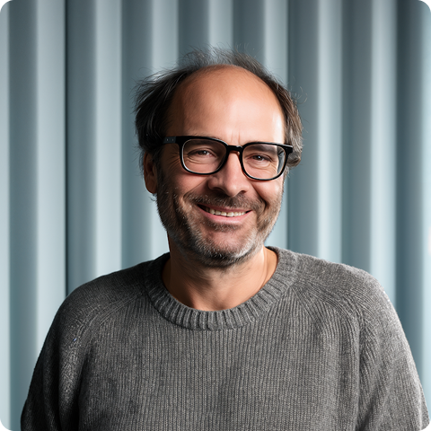 Man with glasses smiling at the camera
